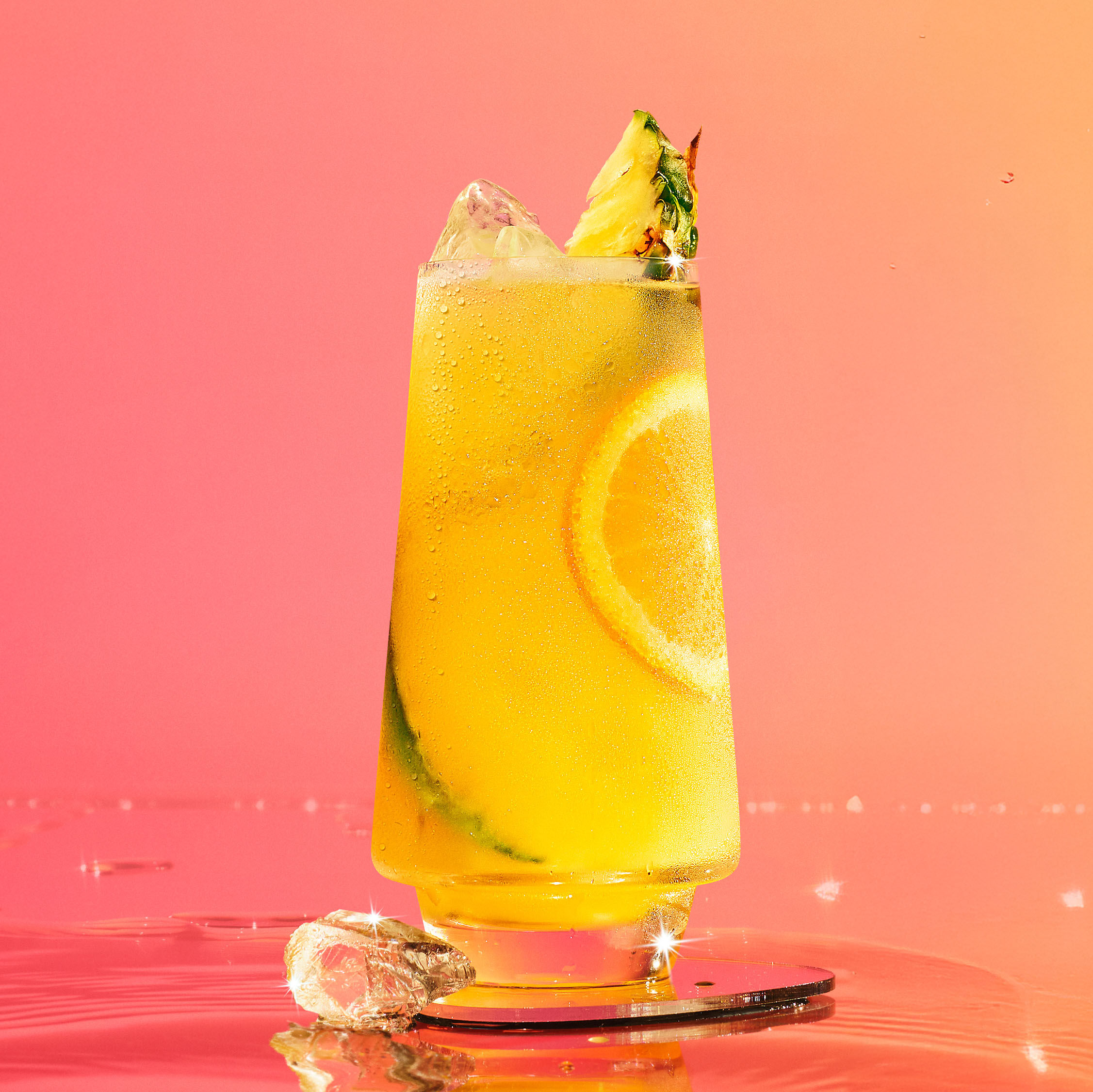 Malibu and pineapple juice in front of a pink peach background