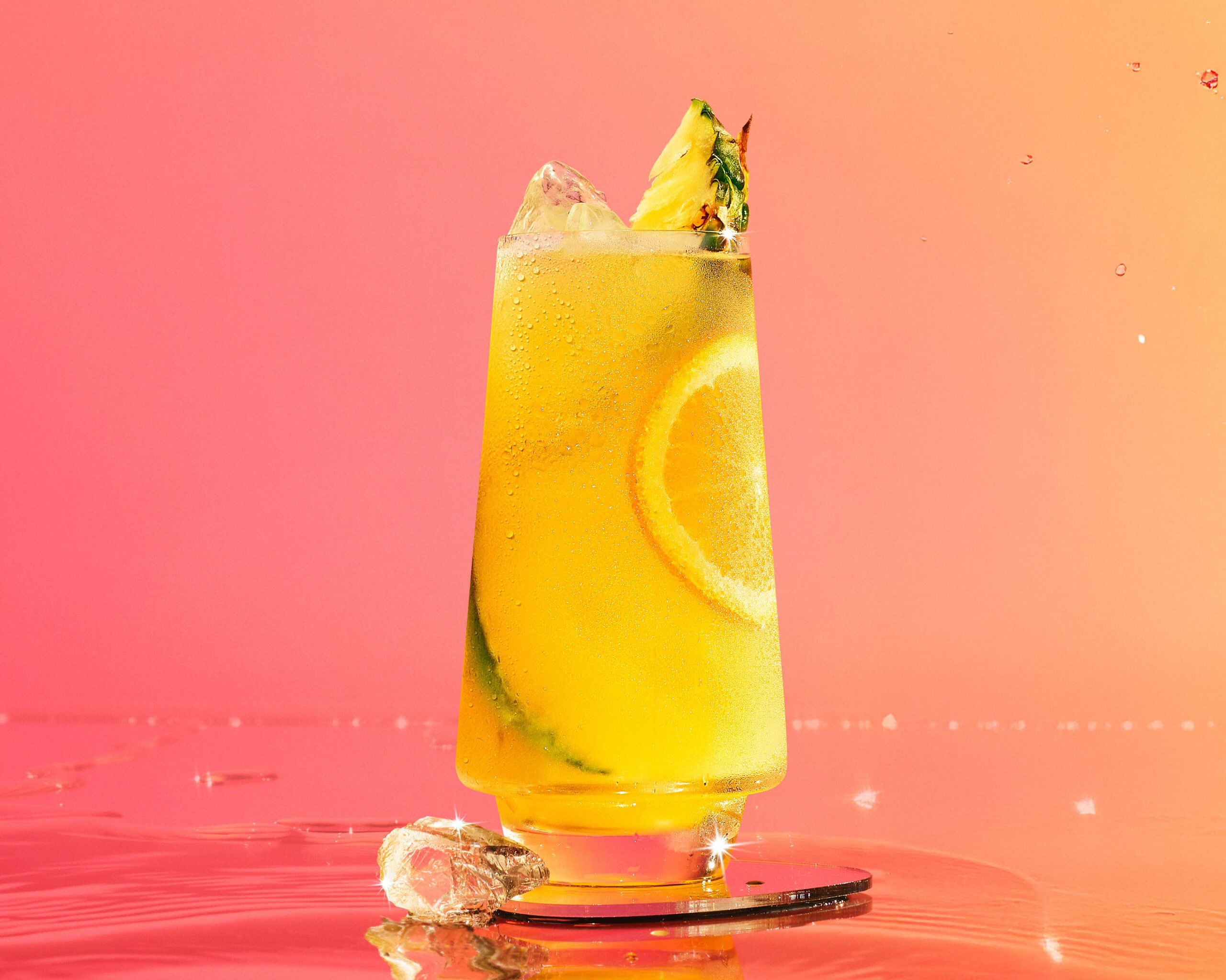 Malibu and pineapple juice in front of a pink peach background