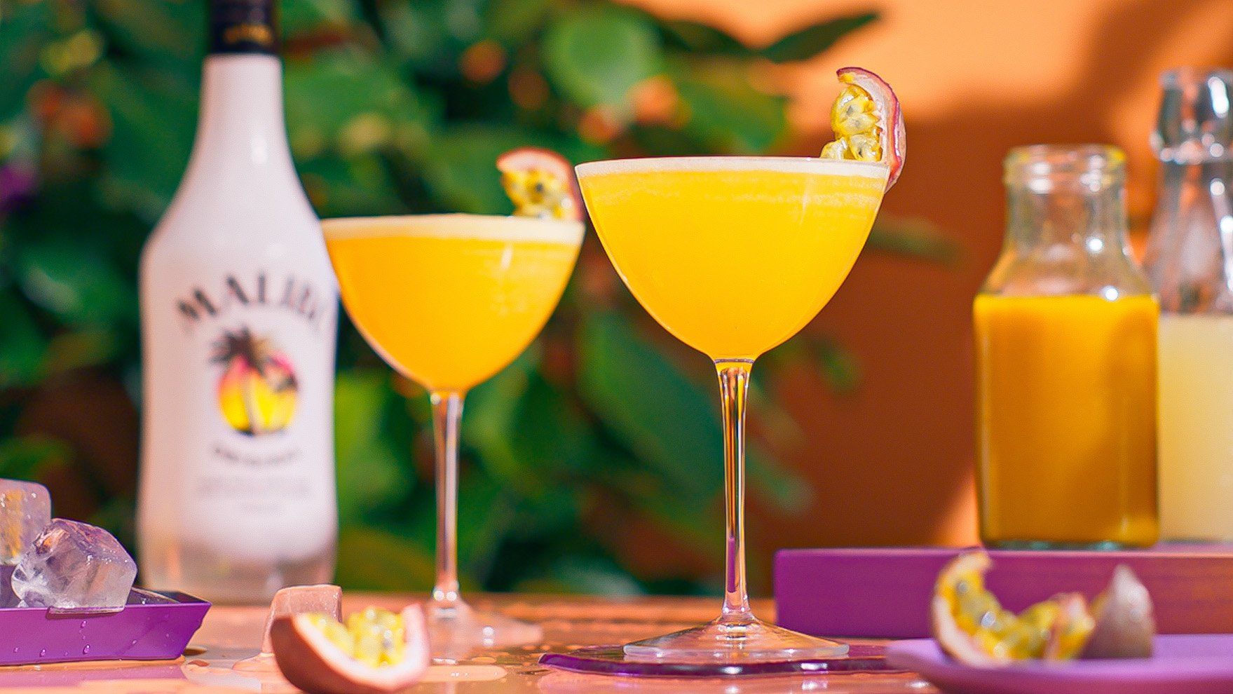 Two Porn Star Martini cocktails on a table with passion fruit garnishes