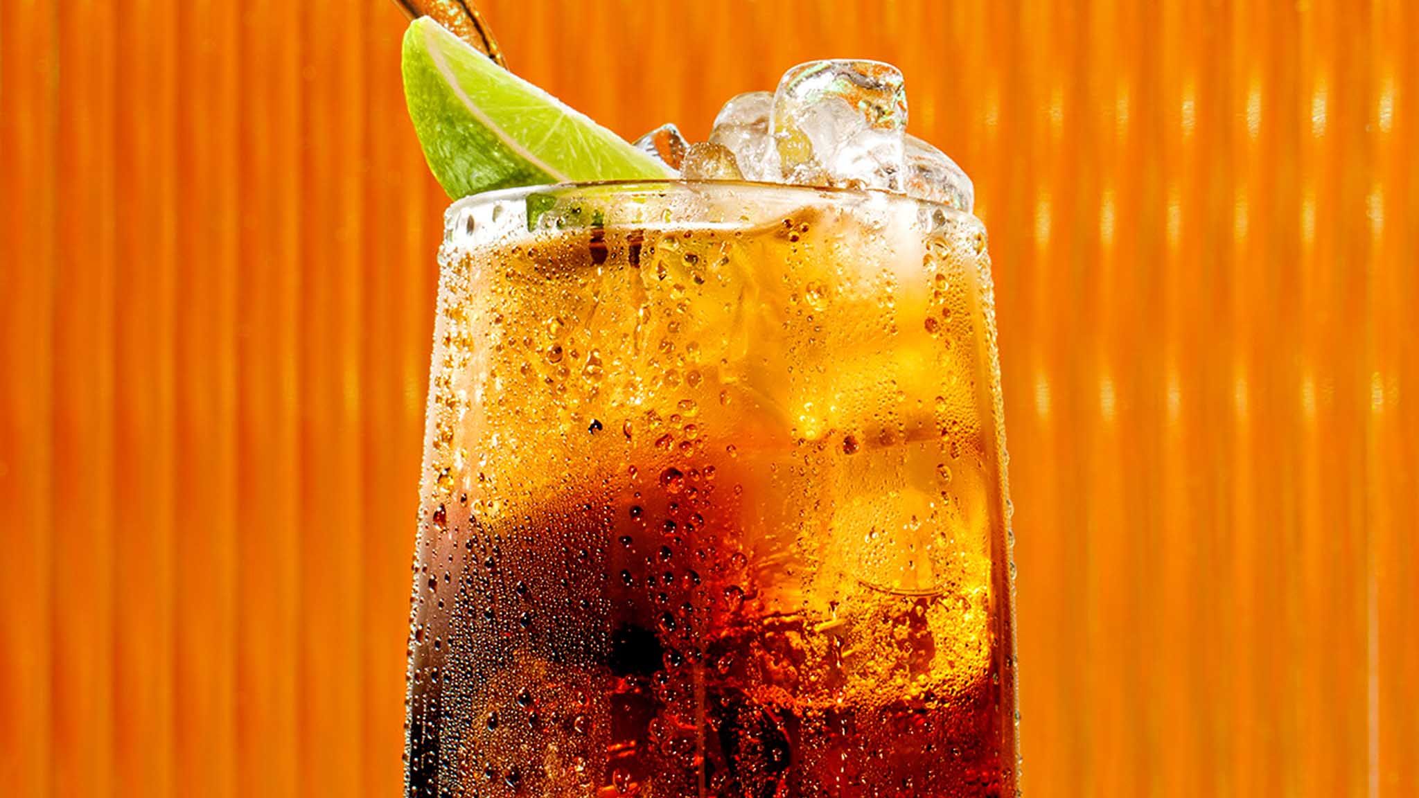 Malibu drink black and cola against an orange background
