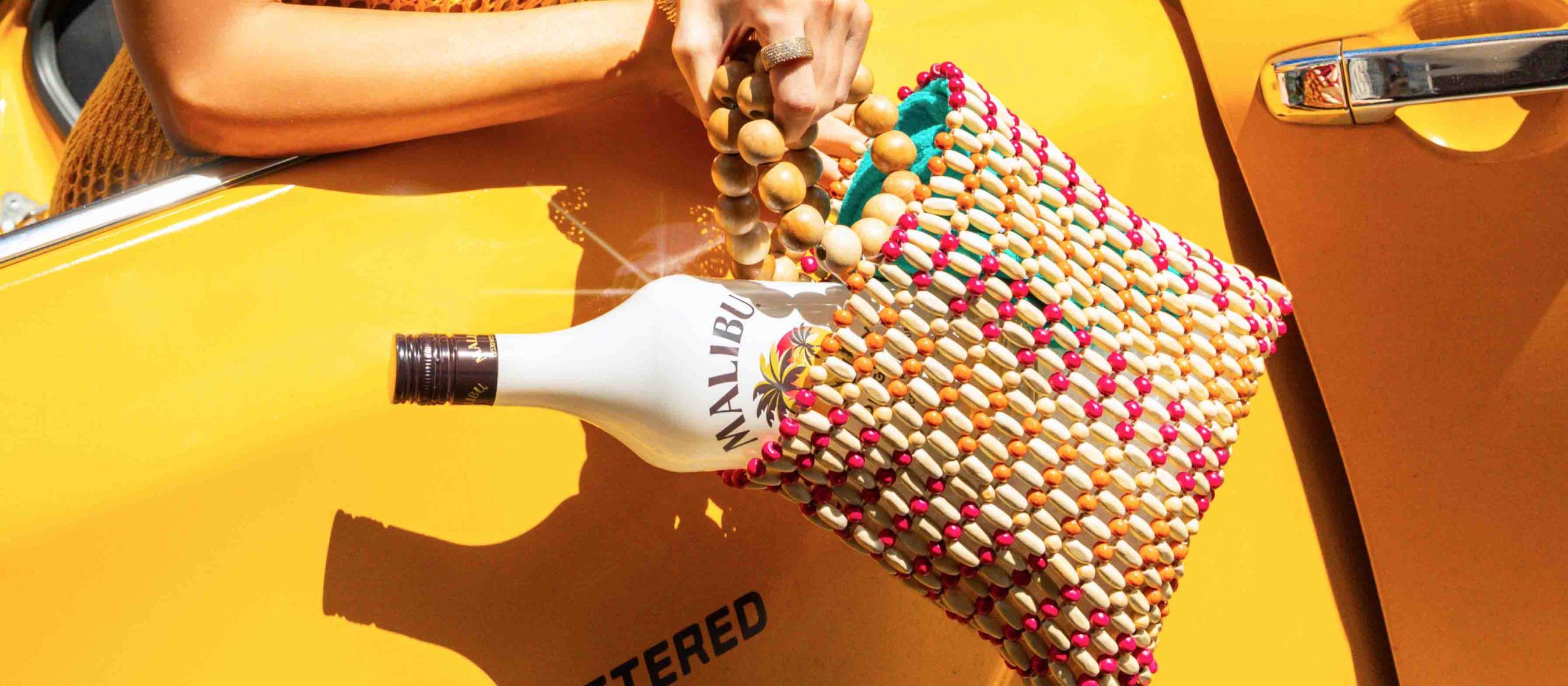 Malibu bottle in a tote bag outside a taxi