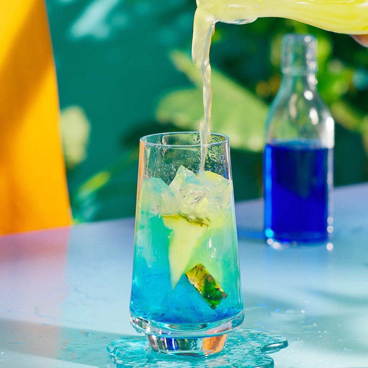 Blue Hawaiian cocktail in a tropical setting being made - step 4