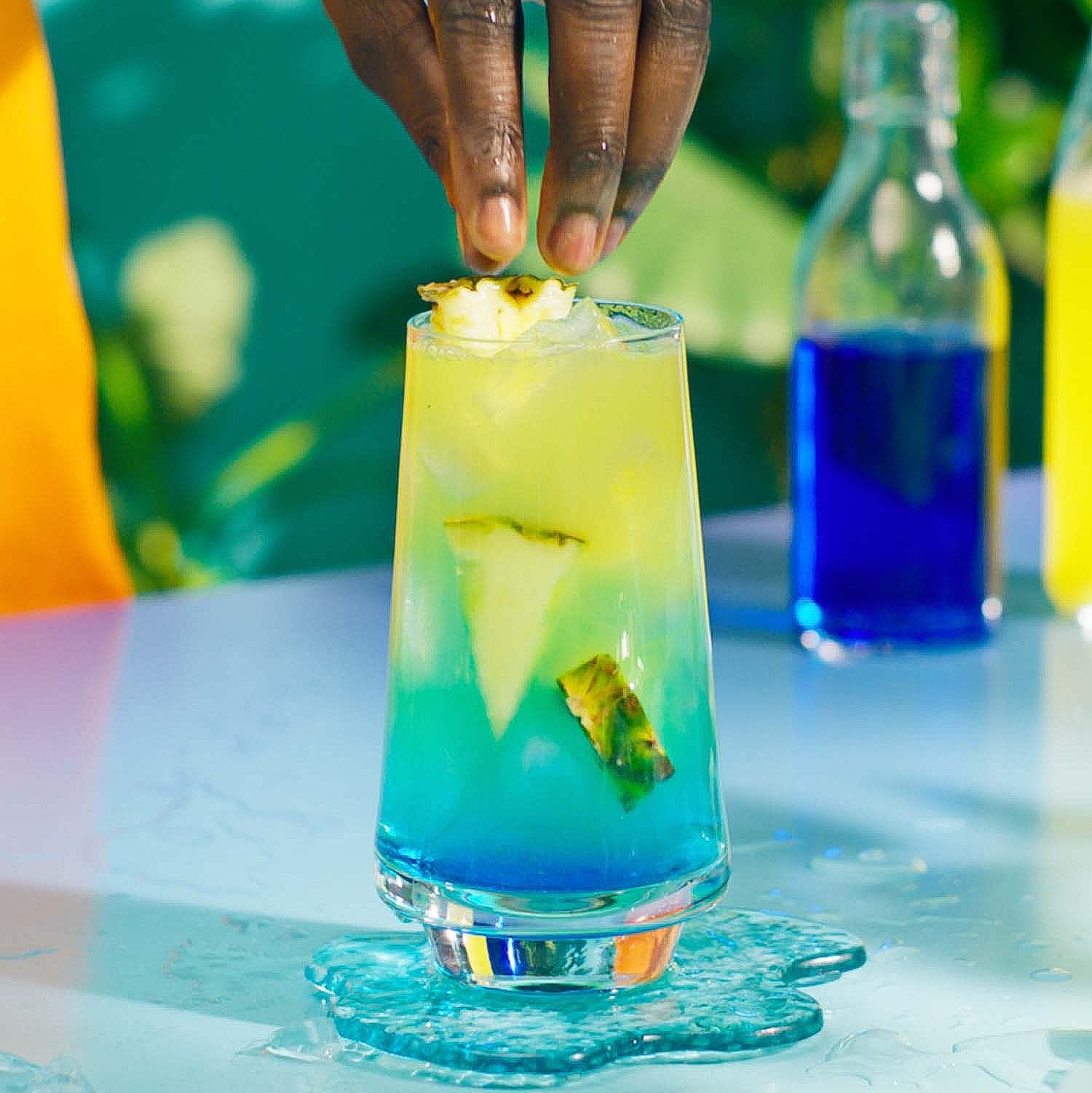 Blue Hawaiian cocktail in a tropical setting garnished with a pineapple - step 5