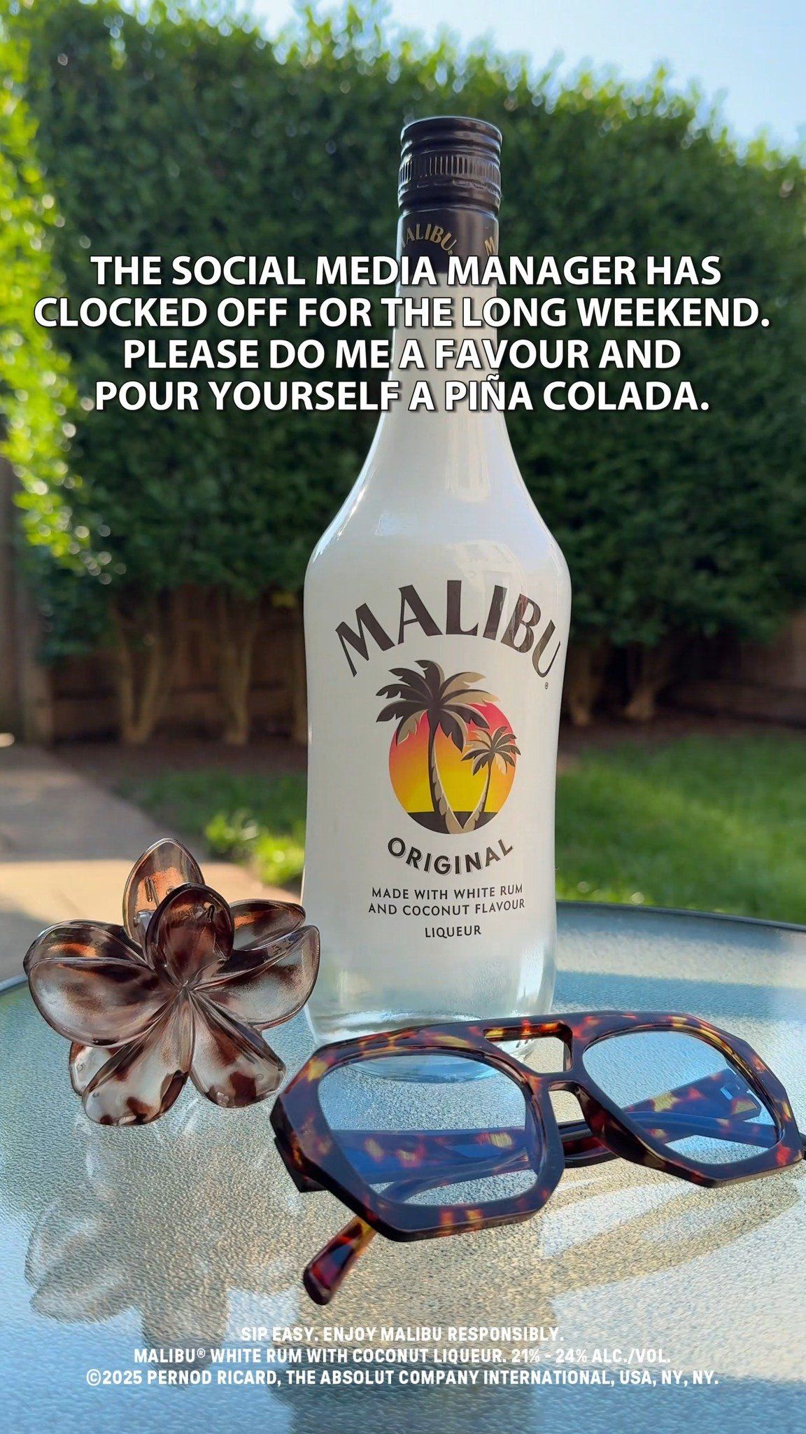 499849919_18499635277027811_4806015054499474822_n Malibu bottle on a table with sunglasses and a flower. Text: Social media manager is off—pour yourself a piña colada.