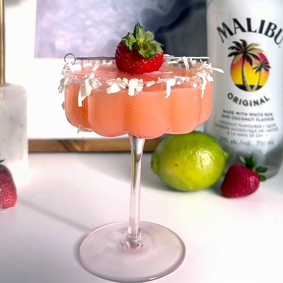 Malibu strawberry and cream daiquiri with strawberry garnish, and malibu bottle in background