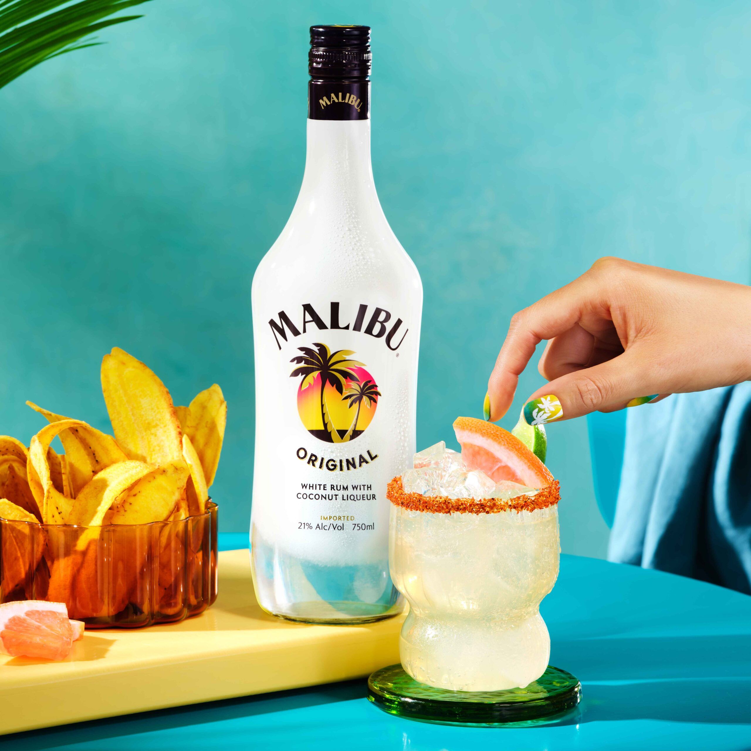 Paloma De Coco cocktail being garnished, next to Malibu Original Bottle