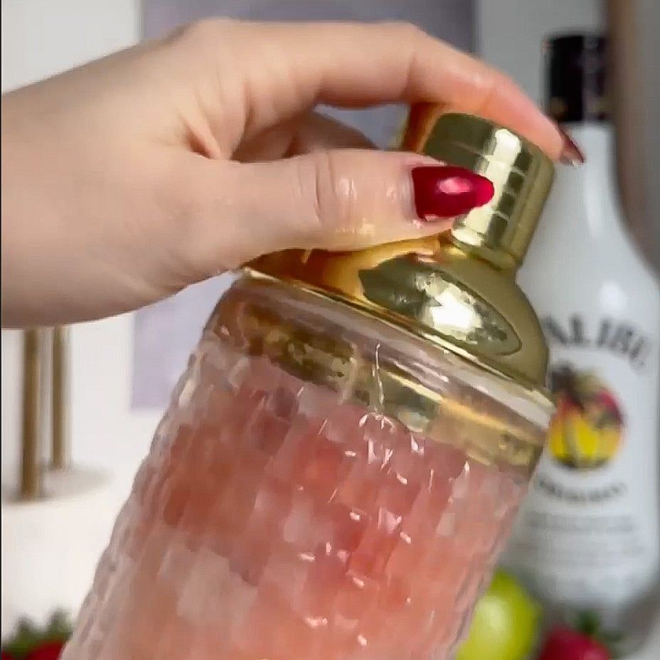 Person shaking a shaker with a lid.