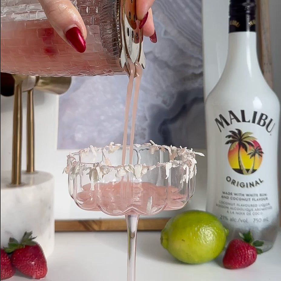 Daiquiri being poured and strained out of shaker into cocktail glass