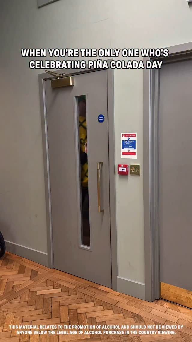 517175040_1409595466984144_7485007242337071513_n Closed office door with someone in a pineapple costume visible through the window. Text reads: 'When you're the only one celebrating Piña Colada Day'.