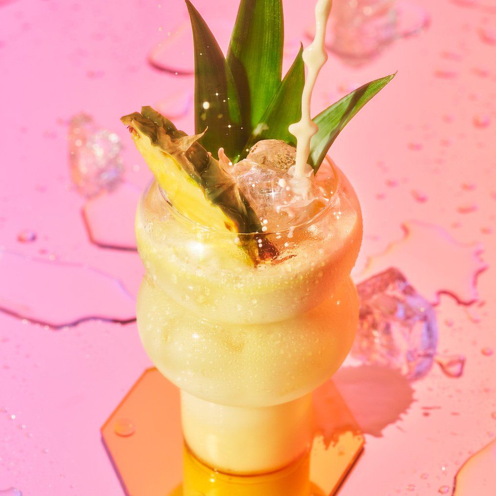 Dirty Coconut Drink on a pink surface with splashes