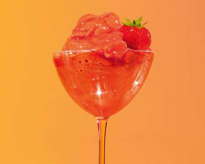 Malibu Frozen Strawberry Daiquiri in a coupe glass with thick red frozen texture and fresh strawberry garnish, glossy surface reflecting light, set against a warm orange background.