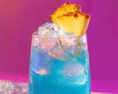 A blue Hawaiian Malibu drink with pineapple and ice