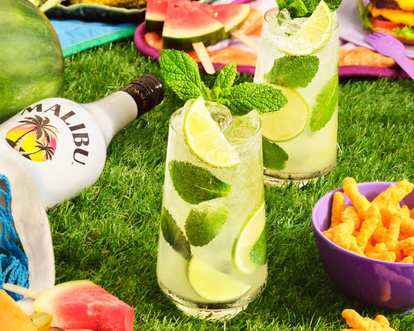 Two refreshing Malibu drinks with mint being served at a BBQ