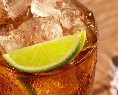 A glass of Malibu and Coke served on ice with lime