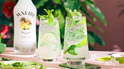 Two Malibu Mojitos and a bottle of Malibu in the background