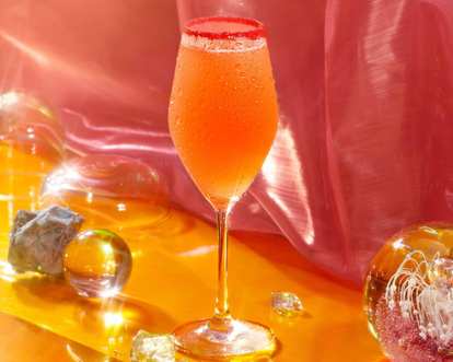 An orange Malibu drink served in a champagne glass perfect for New Years