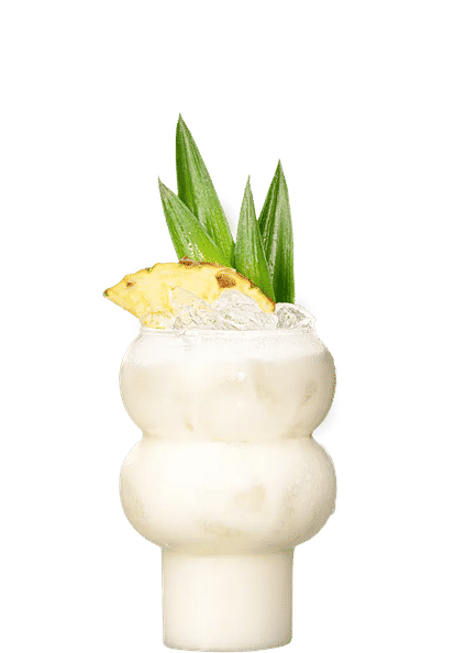 Malibu Pineapple Piña Colada cocktail in a sculpted glass with creamy white drink, ice cubes, pineapple wedge, and green leaves garnish, isolated on a white background.