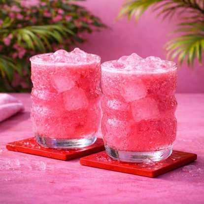 Two Malibu Pink and Soda drinks served in a rocks glass standing on two red