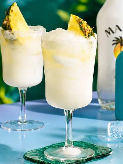 Two Malibu Sparkling Pina Coladas next to bottles
