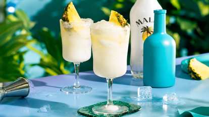 Two Malibu Sparkling Pina Coladas next to bottles