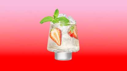 Malibu Strawberry Spritz — a sparkling cocktail with ice, fresh strawberry slices, and mint leaves in a short glass, set against a pink‑to‑red gradient background for a bright, refreshing look.