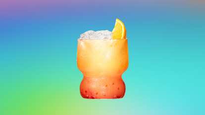 Malibu Sun Berries — a vibrant orange‑to‑red cocktail served in a curvy glass with ice and an orange wedge garnish, glowing against a turquoise‑to‑purple gradient background for a bright, tropical feel.