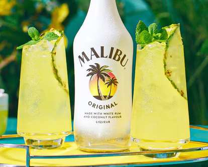 Two glasses of Malibu and Pineapple Juice decorated with mint and pineapple