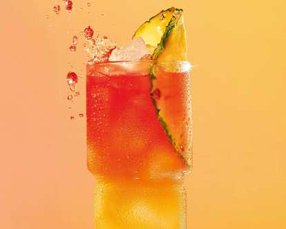 A glass of Pineapple Bay Breeze decorated with a pineapple slice