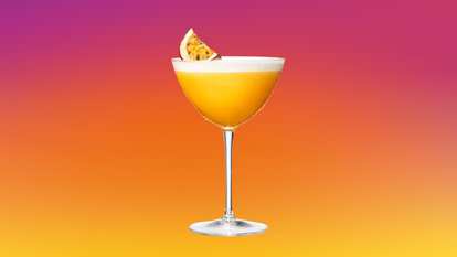 Two Pornstar Martini cocktails standing on a table served in a martini glass
