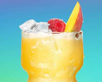 Malibu Raspberry & Mango Mixer cocktail in a short curved glass with bright yellow drink, ice cubes, raspberry, and mango slice garnish, frosted glass surface, isolated on a blue‑green gradient background.