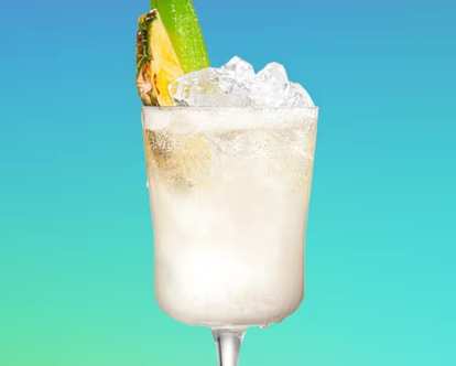 A glass of sparkling Pina Colada decorated with a pineapple slice