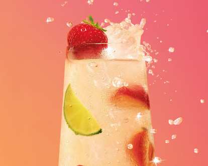 A glass of Malibu Strawberry Lemonade with lime and strawberries