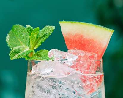 A close up of a Malibu Watermelon drink served with ice and mint