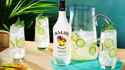 Malibu  El Caribeño made with Malibu  Original rum, cucumber slices, ice, and mint. Served in tall glasses beside a pitcher.